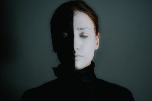 pexels-photo-5785453 A dramatic portrait of a woman with half black and half white face paint, eyes closed, conveying mystery and individuality.